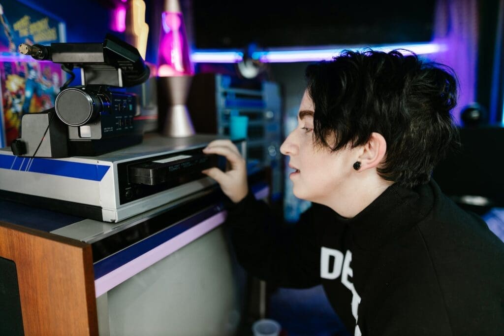man putting video tape into video player